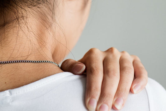 Close-up of a person holding their shoulder to ease muscle soreness and tension