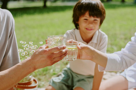 Pamilyang sabay-sabay umiinom ng tubig habang nasa labas upang manatiling hydrated ngayong tag-init